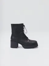 Bota de cuero tipo borceguí con cordones, cierre lateral metálico y taco cuadrado alto con plataforma. Presenta punta cuadrada y diseño robusto.