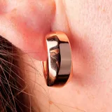 Aros tipo argolla, de diseño grueso y acabado brillante, color dorado rosado.