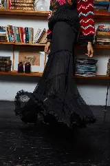 Falda midi de tul negro elastizado con franjas de plumeti y calce evasé. Tiene corte de elástico en la cintura que se amolda a los distintos talles.