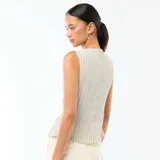 Camiseta de tirantes blanca con rayas sutiles, cuello redondo y cierre frontal de botones metálicos dorados martillados, con abertura inferior.