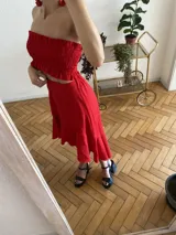 Top color crudo, sin mangas, con frunces en el busto y volados en el ruedo.