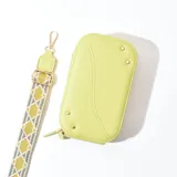 Porta celular color verde con correa de tela estampada y herrajes dorados.