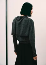 Jersey de punto fino color gris, con cuello redondo y una bufanda integrada del mismo género que cuelga al frente. Cuenta con diseño de manga larga y corte recto.