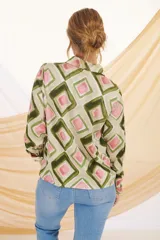 Camisa de manga larga con cuello clásico y cierre de botones. Estampado con motivos florales y geométricos en tonos crudo, azul y negro.