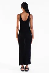 Vestido largo negro de punto con hilo lurex brillante, sin mangas, con escote redondo y aberturas laterales.