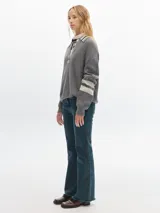 Sweater marrón de punto con cuello polo, escote en V y mangas largas con puños acanalados.