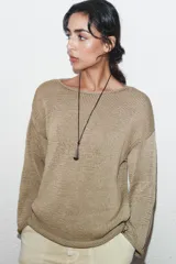 Jersey de punto de manga larga y cuello barco, con diseño holgado y acabado texturizado.