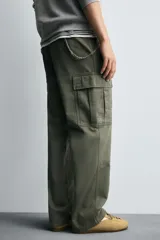 Pantalón cargo de corte recto confeccionado en tejido de algodón. Presenta bolsillos laterales con solapa en las perneras, bolsillos frontales y bolsillos traseros de vivo. Cuenta con cierre frontal de cremallera y botón.