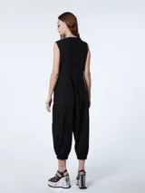 Mono negro de corte baggy, musculosa con botones delanteros anacarados y puño del pantalón con elástico.