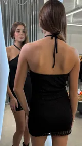 Vestido corto de encaje negro con escote halter y diseño ajustado al cuerpo.
