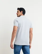 Remera tipo polo de color azul, con cuello clásico, cierre de botones y mangas cortas con terminación acanalada.