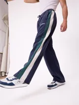 Pantalón tipo babucha de la marca Rusty, color azul petróleo con franjas laterales en color bordó. Presenta cintura elástica con cordón ajustable y logo bordado en la pierna izquierda.