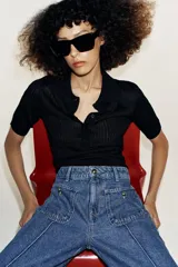 Jeans culotte de tiro alto, color azul, con pernera ancha, nervios marcados en el delantero y bolsillos de parche con botones metálicos. Cuenta con cierre frontal de cremallera y botón metálico.