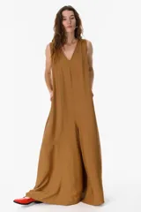 Mono largo color camel, con escote en V, sin mangas y corte holgado. Incluye bolsillos laterales.
