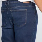 Pantalón de jean azul oscuro, corte slim, con cinco bolsillos y tiro medio.