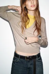 Jersey de punto con lana, de diseño combinado con cuello en V profundo en color beige y detalle interior en color amarillo. Presenta mangas largas con puños ajustados.