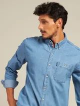 Camisa celeste de manga larga con cuello abotonado y bolsillo en el pecho.