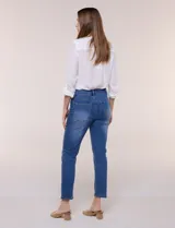 Jean slim skinny de tiro medio en denim azul con proceso de lavado, calce ajustado y largo al tobillo. Cuenta con pretina con presillas, bolsillos delanteros y traseros, y acceso frontal con botón y cierre.