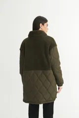 Campera negra con parte superior de sherpa y parte inferior de nylon capitoneado con forro de nylon.