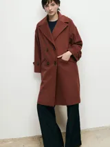 Tapado marrón de paño con doble botonadura, cuello solapa y bolsillos laterales.