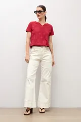 Remera roja de manga corta con escote en V y diseño de estampado en relieve en la parte delantera.