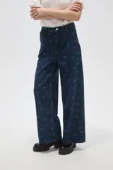 Pantalón de jean azul oscuro de corte ancho, con tiro alto, pinzas frontales y estampado de lunares.
