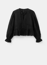 Blusa de algodón negra con detalles florales bordados, cuello en pico con cierre de lazo, manga larga abullonada y diseño recto con vuelo en la cintura.