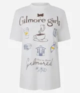 Remera de algodón color blanco con cuello redondo y manga corta. Presenta un estampado temático de la serie Gilmore Girls en la espalda con diseño de taza de café y texto descriptivo.