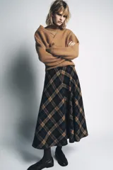 Falda midi de tiro medio con estampado de cuadros en tonos azul marino, marrón y beige. Confeccionada en hilatura con mezcla de viscosa, presenta un bajo acabado en línea evasé y cierre con cremallera oculta en la costura.