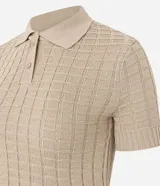 Blusa color beige de tejido de punto con textura cuadriculada, corte crop, cuello polo con cierre de botones y mangas cortas ajustadas.