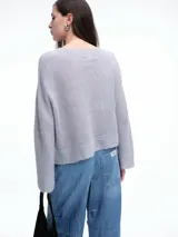 Sweater de punto negro con lentejuelas sutiles, de corte holgado, hombros caídos y mangas largas con terminación acampanada.