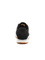Championes Caterpillar modelo Ventura para mujer, de color negro con suela de goma caramelo y entresuela blanca. Confeccionados con capellada de gamuza y lona, cordones negros y el logo de la marca impreso en el lateral y la lengüeta.
