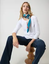 Pashmina cuadrada de satén con estampado multicolor en tonos naranja, azul y crema.