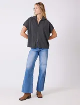 Cardigan gris jaspeado de punto de galga media, con cierre frontal metálico completo y cuello con solapa. Presenta mangas cortas de sisa caída y un corte recto y holgado que llega a la altura de la cadera.