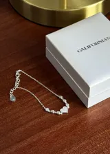 Pulsera de plata 925 con cadena eslabonada tipo forcé, decorada con circones engastados como puntos de luz y un dije central en forma de corazón cubierto de circones pavé. Cuenta con cadena de extensión terminada en un pequeño dije con forma de corazón y cierre de mosquetón.