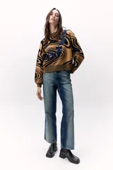 Sweater tejido de punto color azul con diseño marmoleado en negro y aplique bordado con contorno verde.