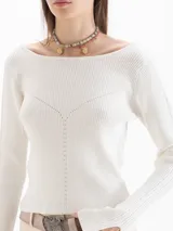 Top de punto color blanco con escote bote, mangas largas con abertura en los puños y detalles de tejido en relieve en la parte frontal y mangas.