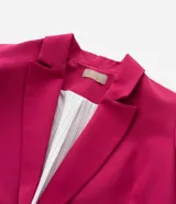 Blazer sastre de corte alargado y diseño minimalista sin botones. Presenta cuello con solapas clásicas, mangas largas y bolsillos laterales tipo vivo. Confeccionado en tejido estructurado con forro interior.