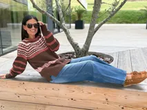 Sweater de punto con diseño jacquard en la parte superior, cuello redondo y mangas largas. Presenta una combinación de colores en tonos tierra, marrón y rosado.