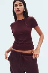 Remera de manga corta, color bordó, con cuello redondo y corte entallado.