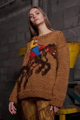 Sweater tejido de lana color marrón con bordado de un jinete a caballo. Tiene cuello redondo y puños acanalados.