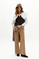 Pantalón de corte recto y pierna levemente ancha, confeccionado en pana de algodón color camel. Presenta cintura media, cierre frontal con gancho oculto y bolsillos laterales y traseros.