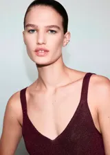 Top de punto fino con lurex, color bordó, de corte recto, escote en V y tirantes finos.