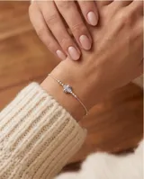 Pulsera de plata 925 con diseño de cadena fina, detalles de cuentas esféricas y un dije central en forma de trébol compuesto por cuatro pequeños corazones, algunos con apliques de circón.