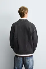 Chaqueta tipo bomber de punto compacto con efecto lavado, cuello subido, manga larga y cierre frontal con cremallera. Presenta bolsillos de vivo en la cadera y acabados en rib.