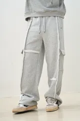Pantalón de jogging gris melange de corte ancho, con bolsillos laterales y detalles de costuras blancas a contraste.