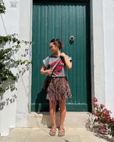 Bandolera de cuero marrón con correa corta y correa larga intercambiables, forro interior y bolsillo con cierre.