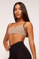 Top deportivo color beige con tirantes finos negros en contraste.