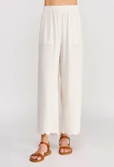 Pantalón palazzo de tiro alto color beige, confeccionado en mezcla de lino y viscosa, con silueta suelta y fluida, cintura elastizada, bolsillos delanteros aplicados y ruedo festoneado de corte tobillero.