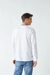 Remera de manga larga blanca con cuello redondo y estampado frontal con imagen de un pianista y texto en color celeste.